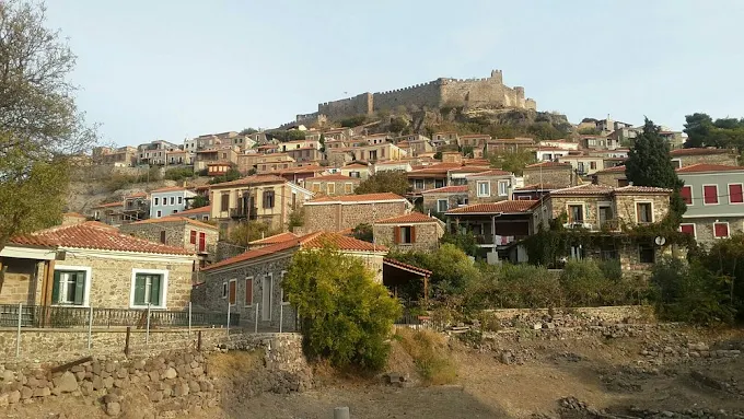 Molyvos Castle Byzantine fortress overlooking traditional village and Aegean Sea at golden hour on Lesbos Greece