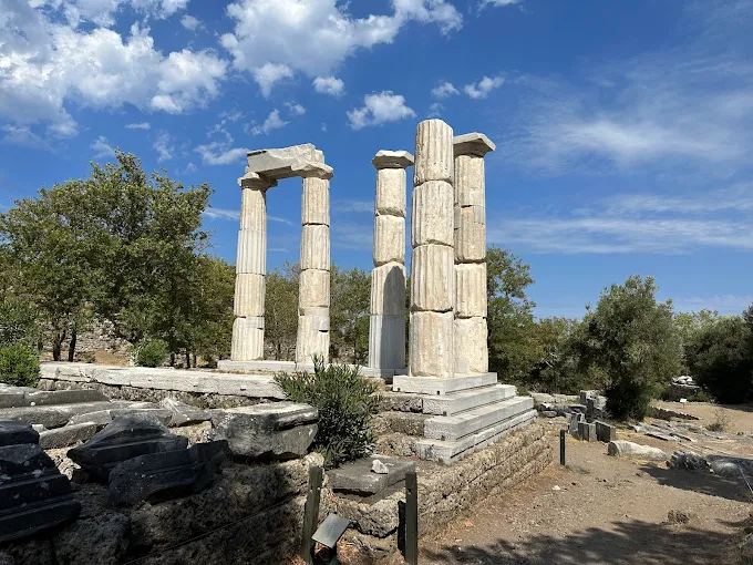 Samothrace Sanctuary of the Great Gods at golden hour with ancient marble ruins nestled in forested Aegean hillside
