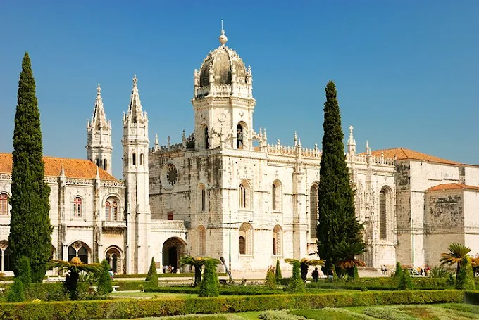 Jerónimos Monastery Lisbon at golden hour with Manueline cloister arches and limestone façade bathed in warm afternoon light