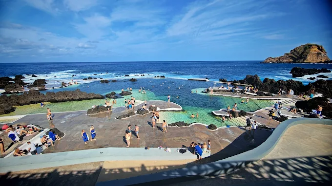 Volcanic rock natural swimming pools filled with turquoise Atlantic seawater in Porto Moniz, Madeira at golden hour