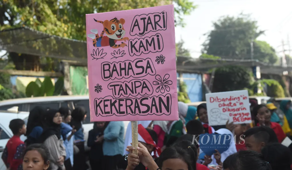 Anak-anak membawa poster menyuarakan hak anak di kampung Surabaya