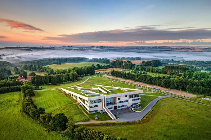 Moesgaard Museum sloping green roof architecture overlooking Aarhus Bay forest landscape at golden hour in Denmark