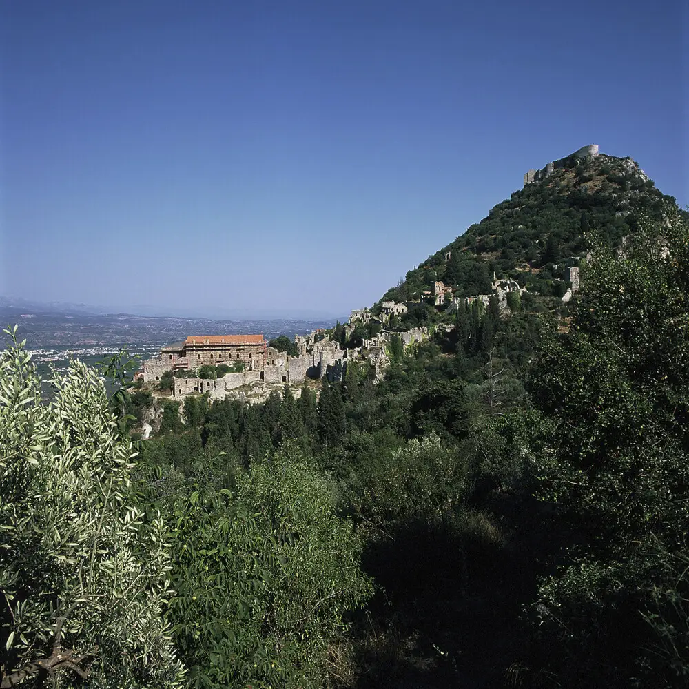 Mystras Byzantine ruins at golden hour with frescoed churches, stone fortifications, and Evrotas Valley Peloponnese Greece mountain landscape