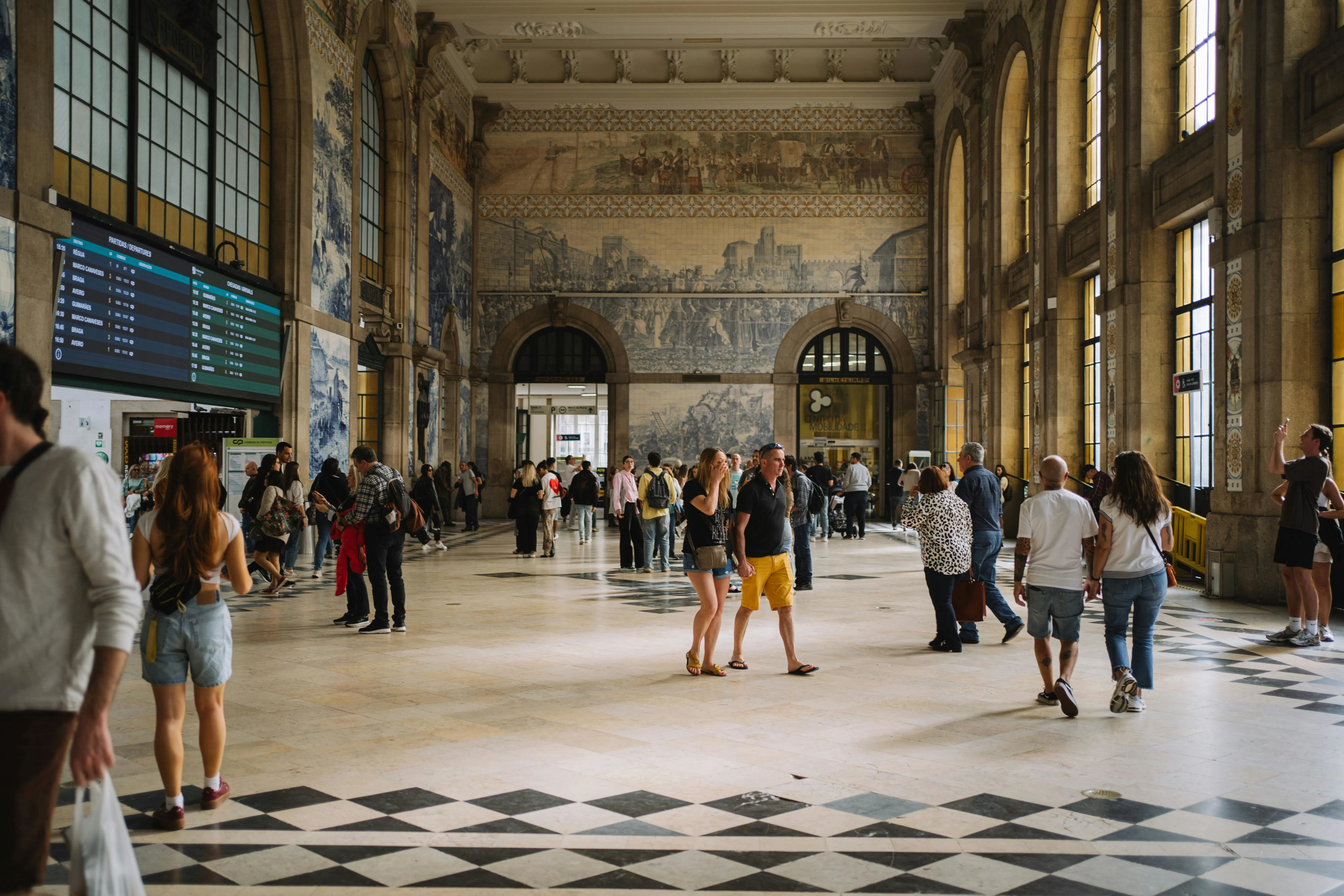 Morning light illuminating the intricate blue and white azulejo panels inside São Bento Station in Porto.