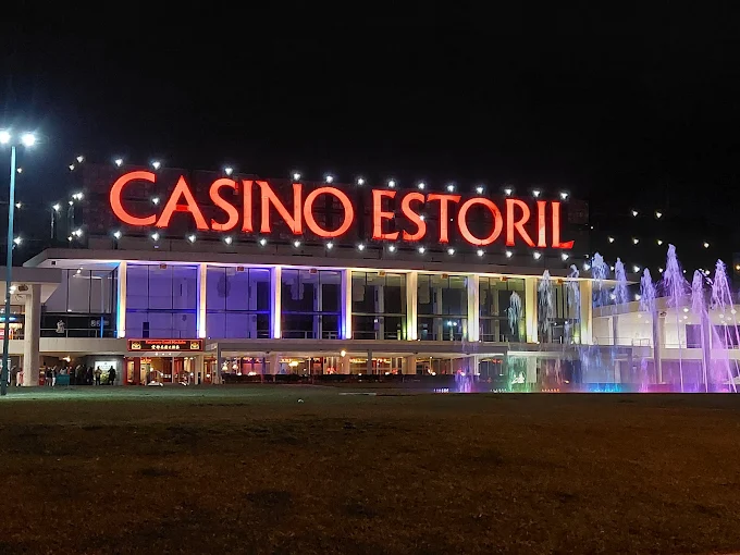 Evening illumination highlighting the neoclassical façade of the Estoril Casino in Portugal.