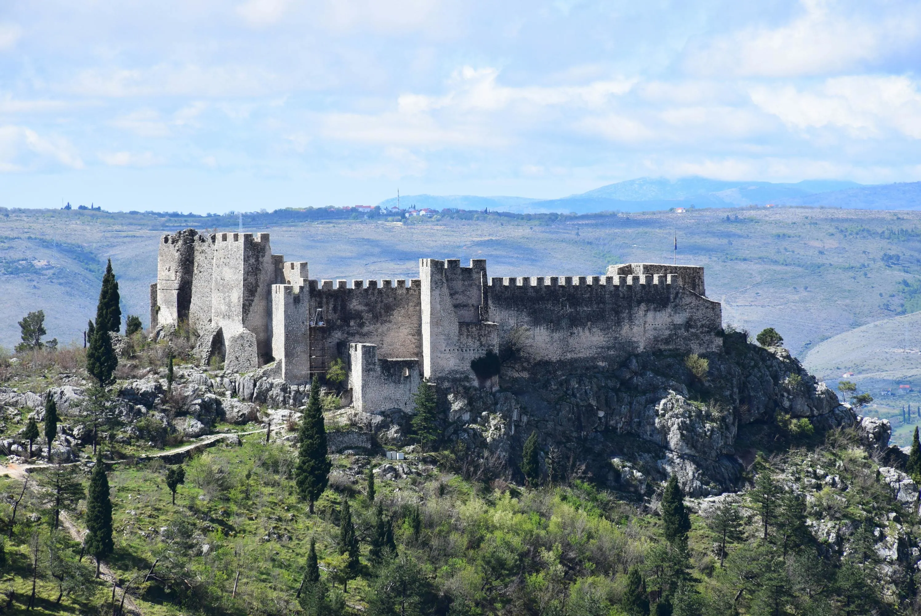 Dramatic hilltop stone walls of Marvão fortress piercing through thick morning fog with sweeping valley views