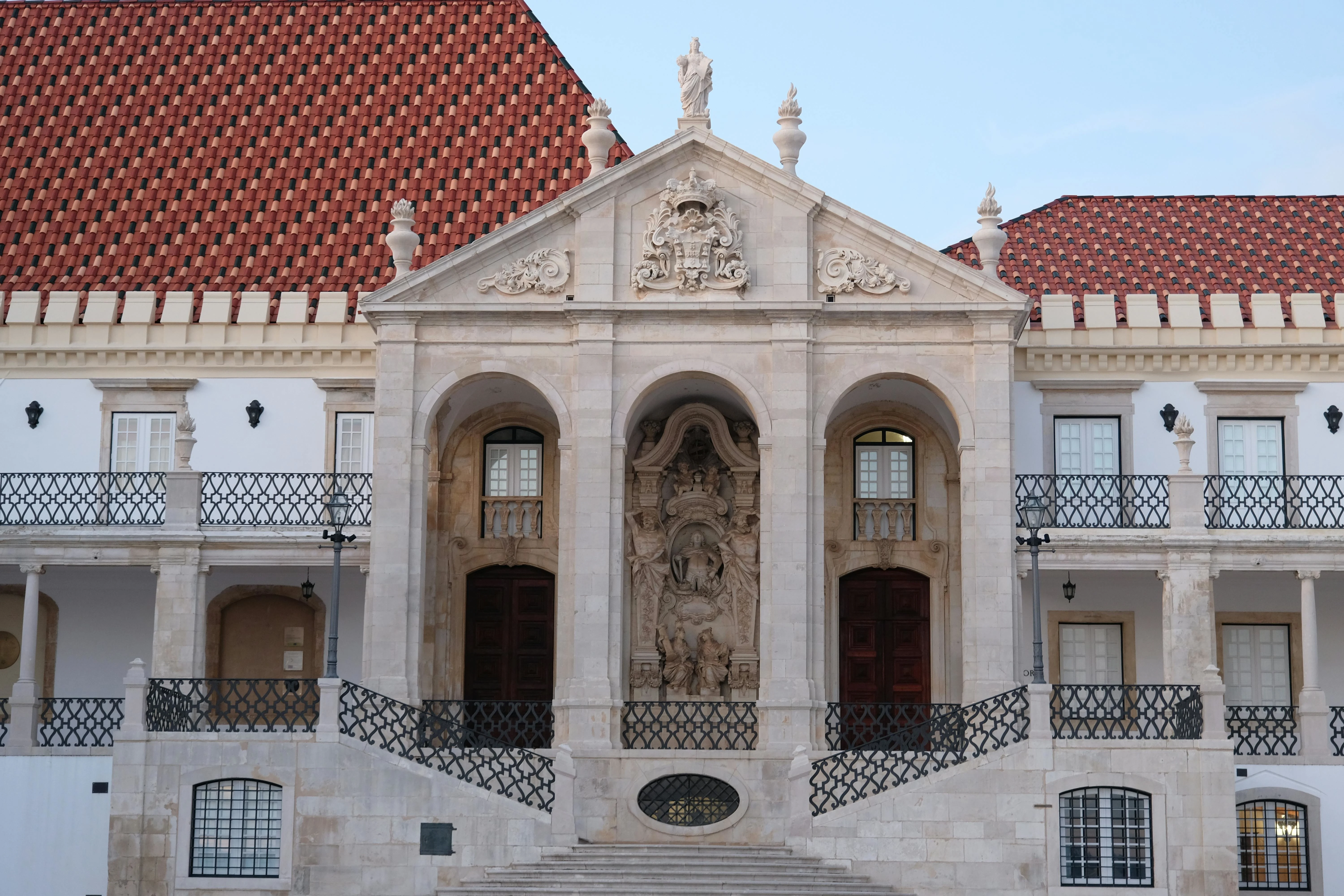 Majestic Joanina Library facade of Coimbra University bathed in warm golden afternoon light with Baroque details