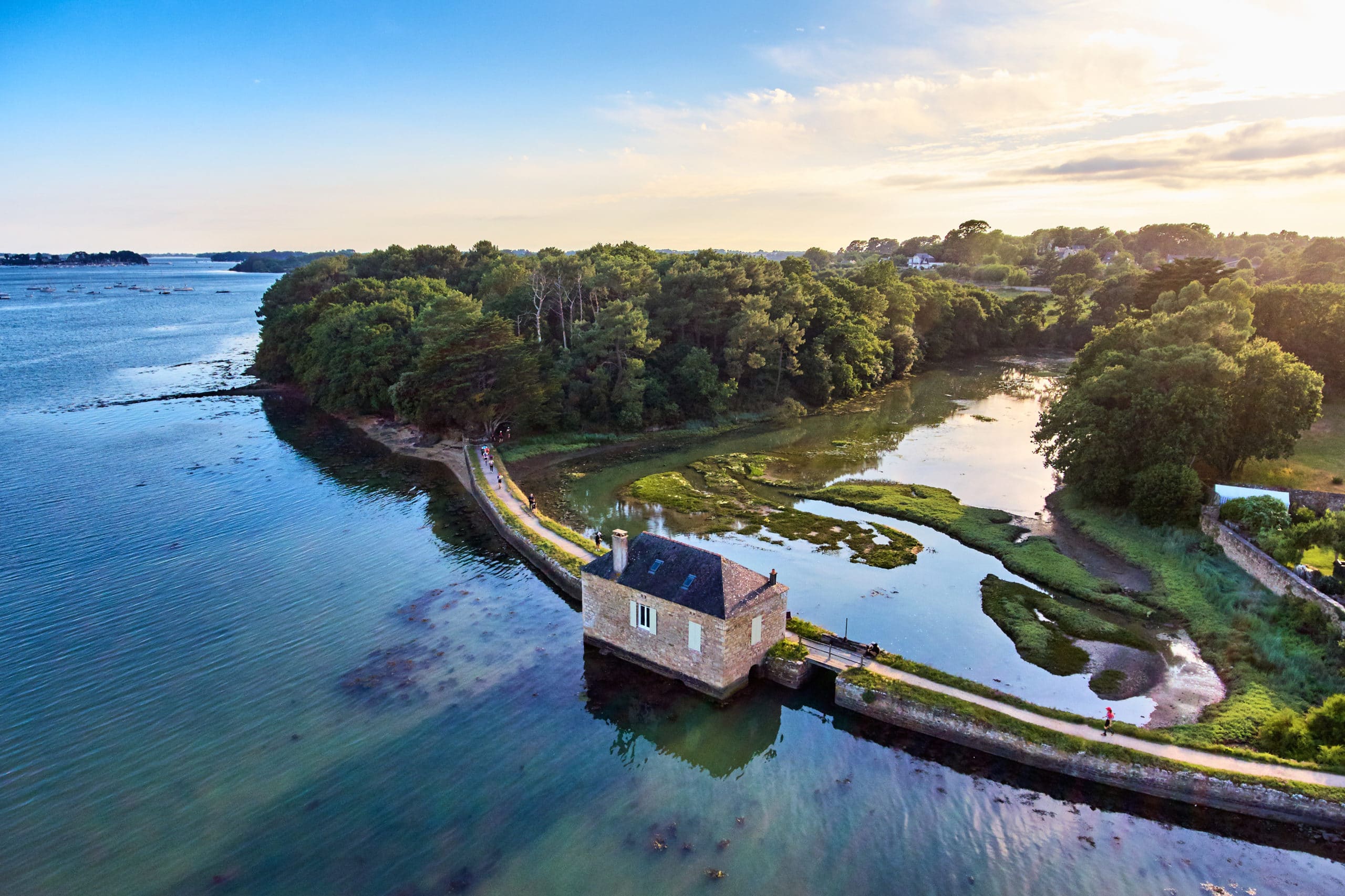 Gulf of Morbihan with turquoise waters, scattered islands, traditional boats, and megalithic sites under soft Breton morning light in Brittany, France