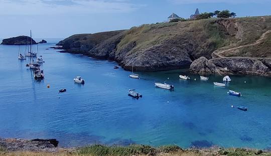 Belle-Île-en-Mer with dramatic coastal cliffs, turquoise coves, and white lighthouse under golden Breton morning light in Brittany, France