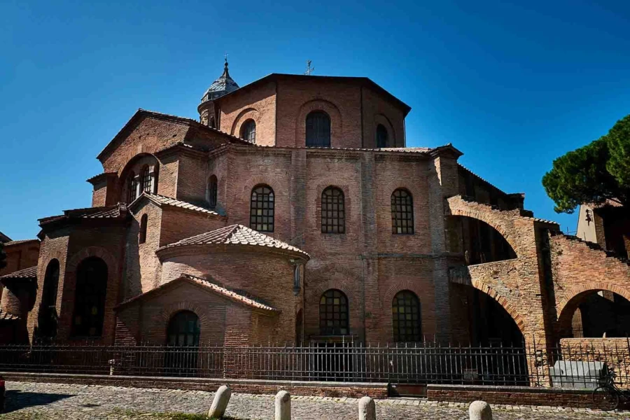 Ravenna mosaics at golden hour, shimmering gold and blue Byzantine tiles glowing in the Basilica of San Vitale