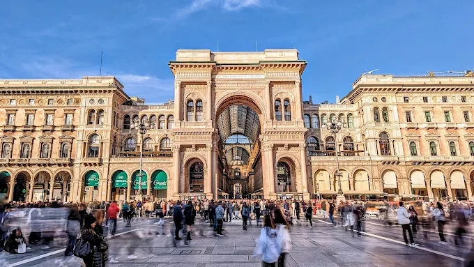 Galleria Vittorio Emanuele II in Milan at golden hour, glass-vaulted arcade glowing with warm light and elegant storefronts