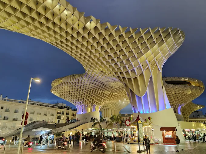 Metropol Parasol wooden structure at sunset with honeycomb canopy, elevated walkway, and Plaza de la Encarnación bathed in warm golden Andalusian light