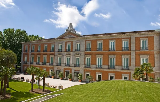 Thyssen-Bornemisza Museum Madrid neoclassical palace hall with paintings, sculptures, and visitors bathed in soft natural light from skylights