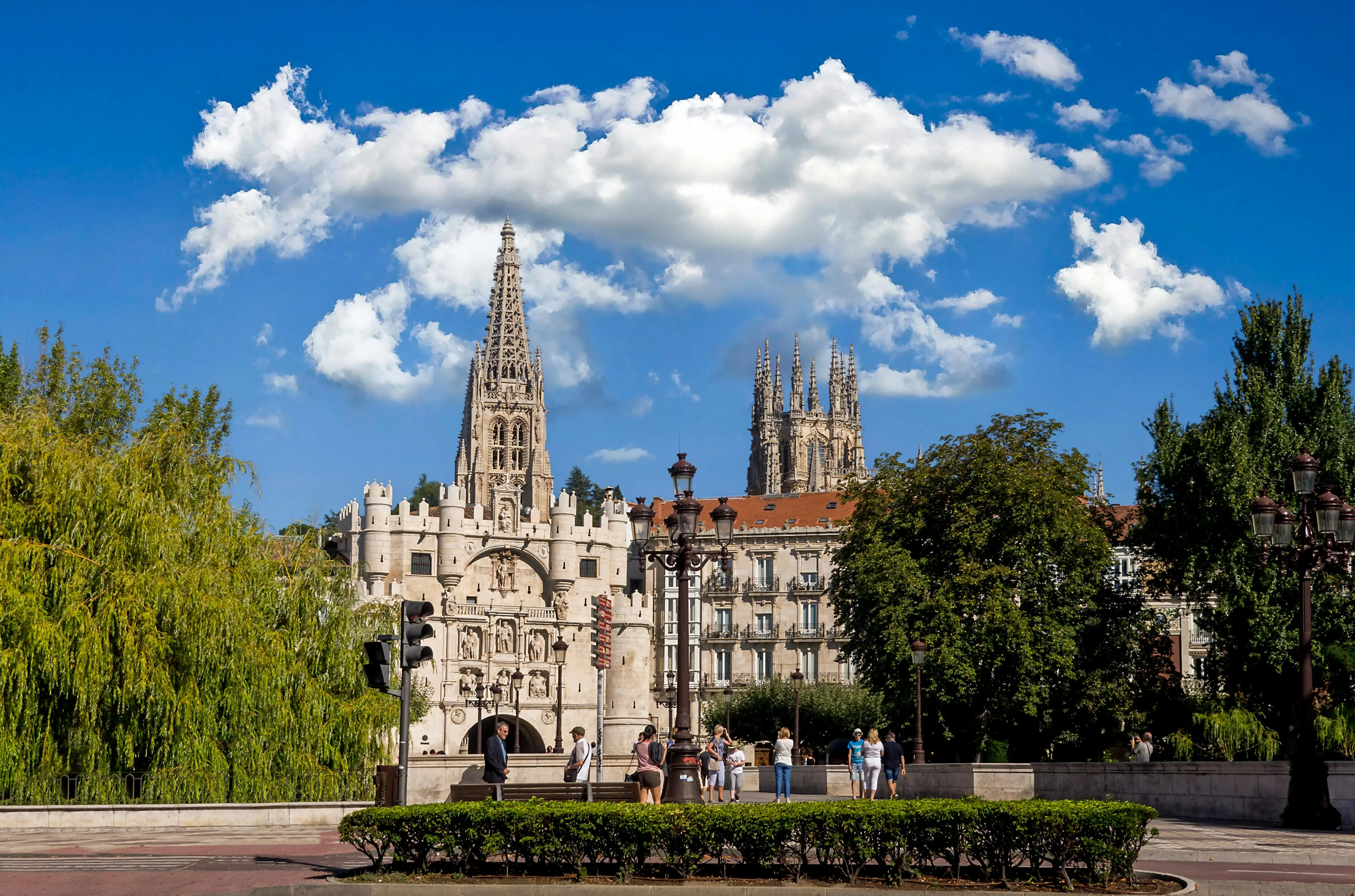 Burgos Cathedral Gothic spires illuminated at sunset in Castilla y León, Spain with dramatic sky and plaza foreground