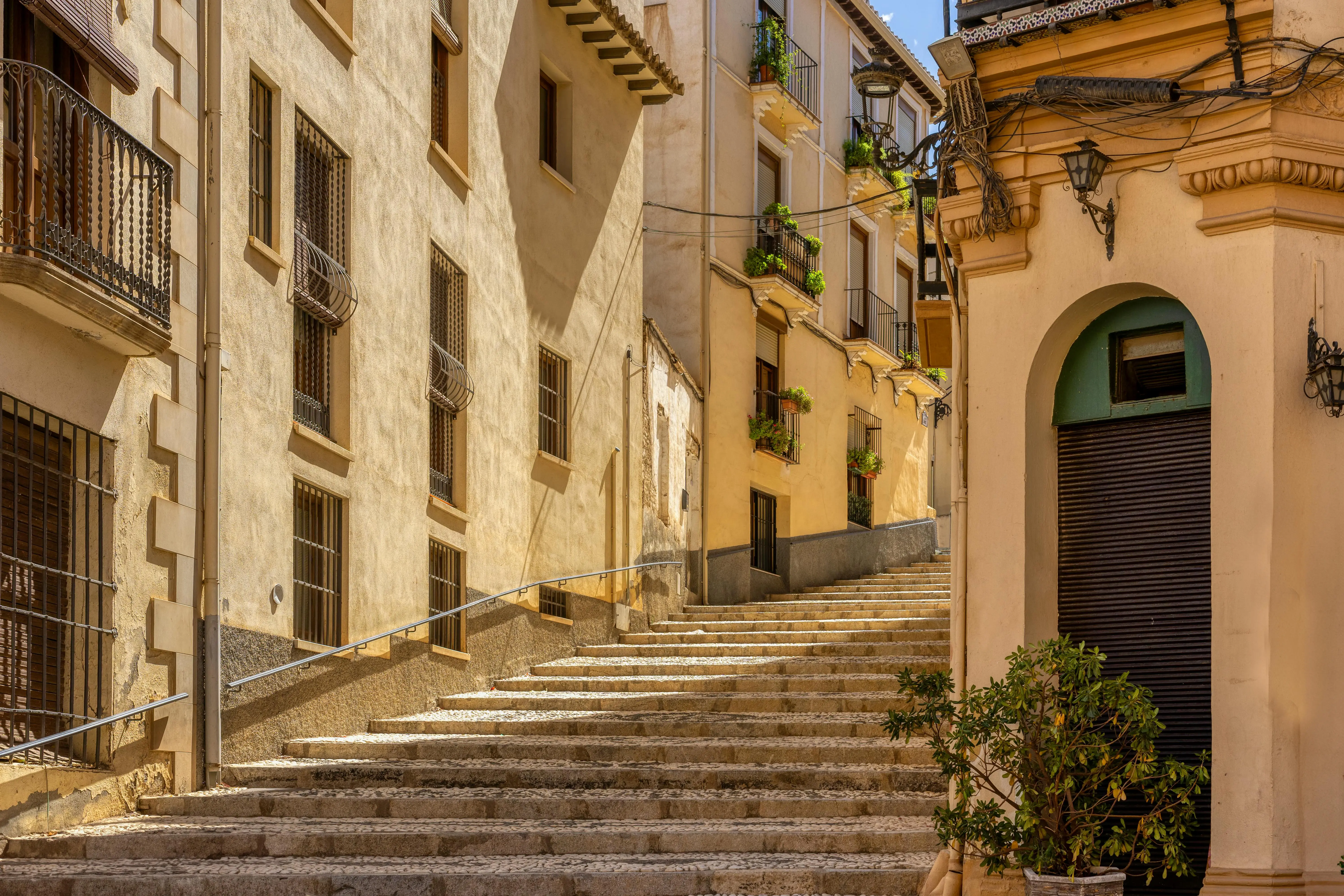 Girona Jewish Quarter narrow stone streets at dusk with warm lantern light illuminating medieval architecture, Catalonia, Spain