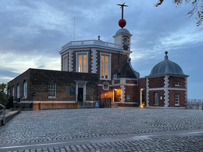Royal Observatory Greenwich onion domes at sunset with Prime Meridian line and London skyline in background