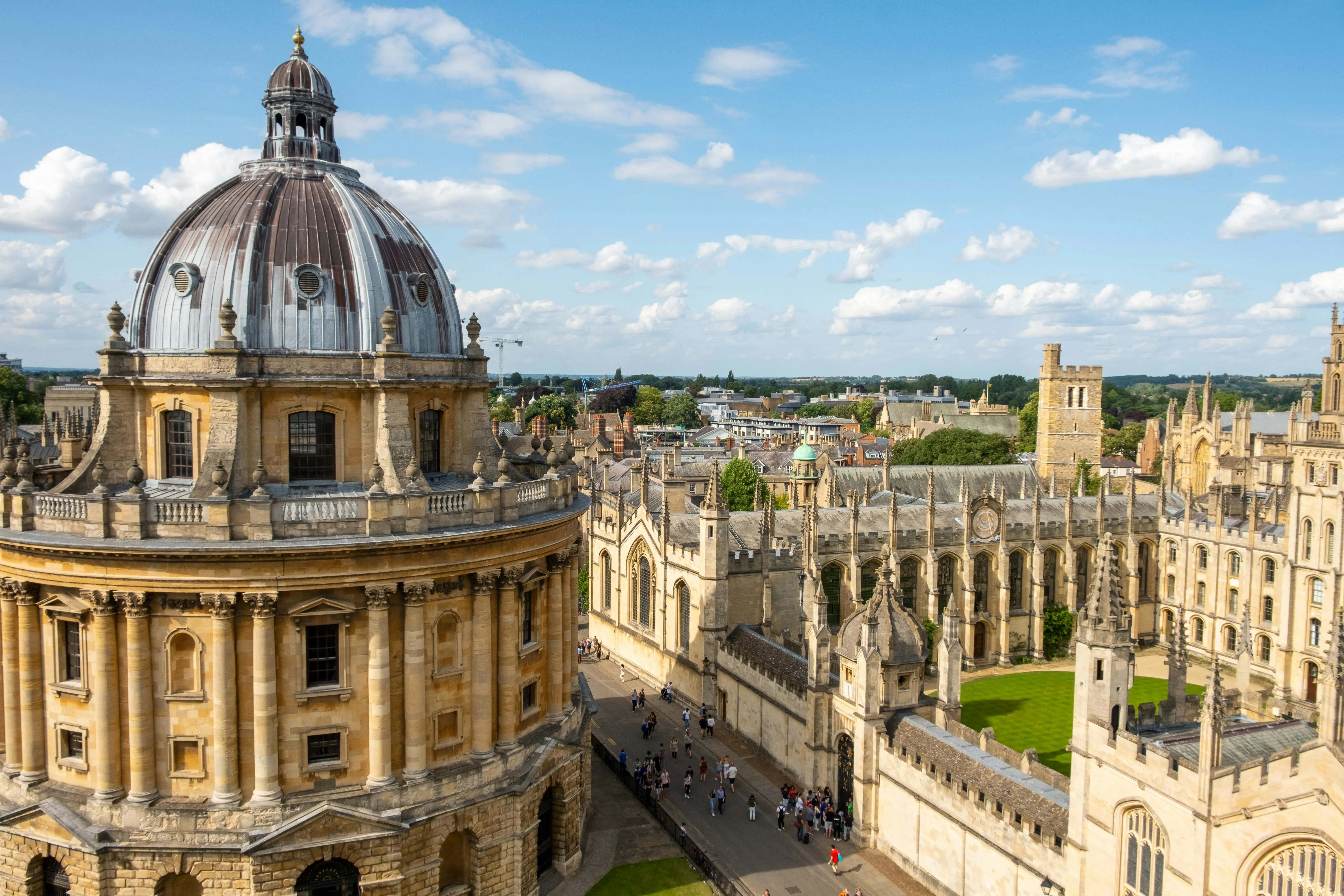 Oxford University Radcliffe Camera at golden hour with students cycling past historic limestone buildings England