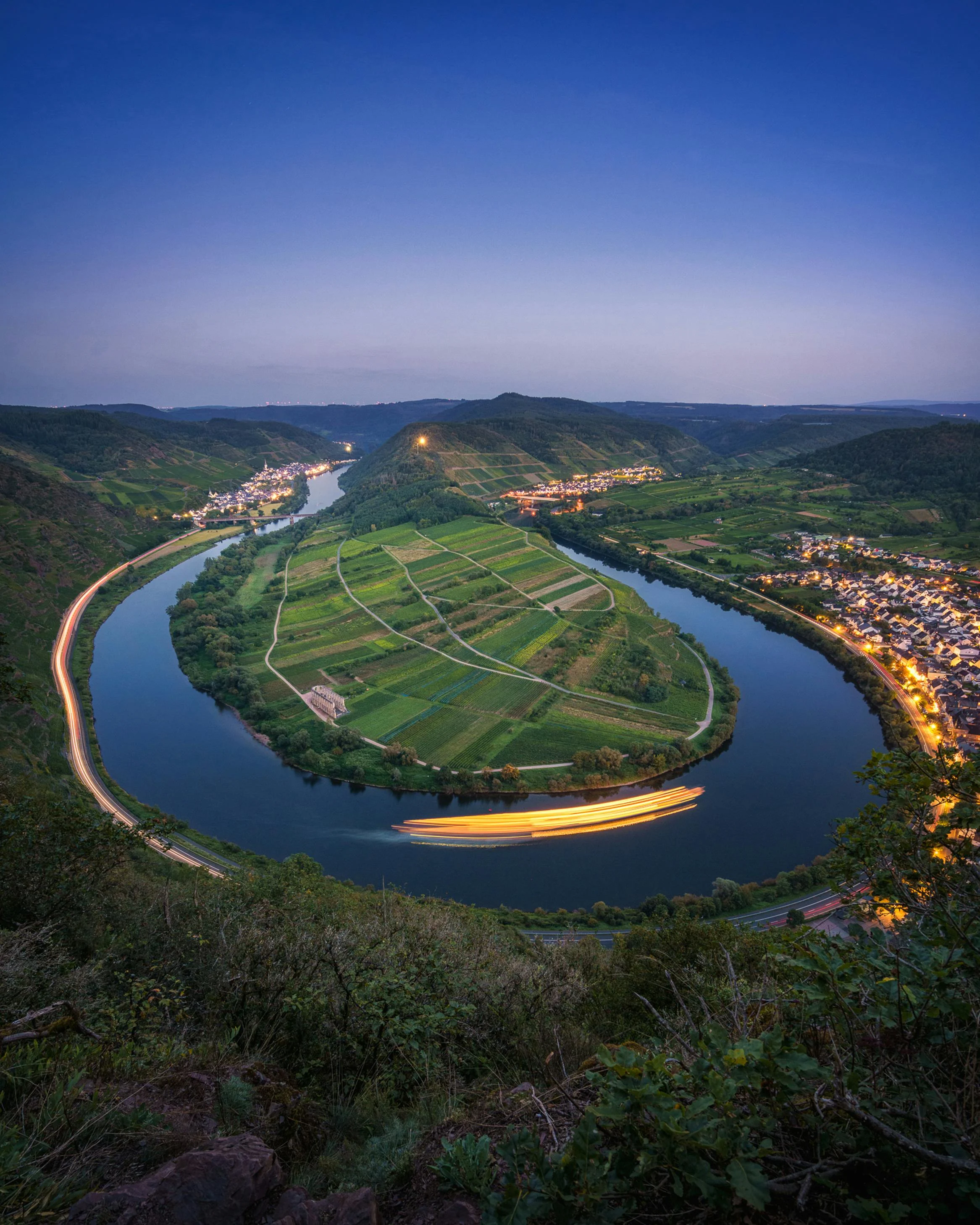 Steep Moselle Valley vineyards at sunrise with terraced rows, river bends, and historic villages in Germany