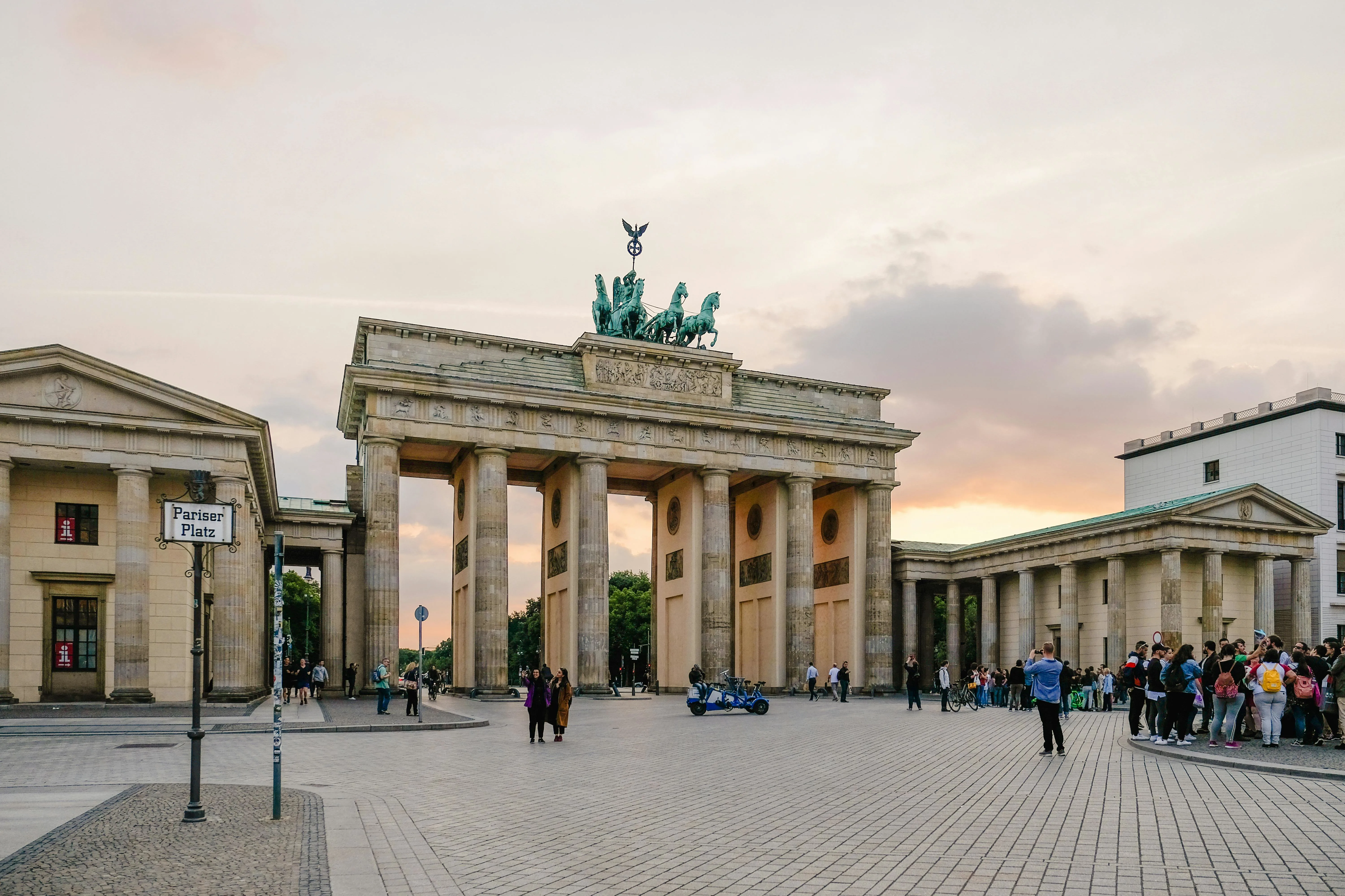 Brandenburg Gate at golden hour with neoclassical columns, Quadriga statue, and Pariser Platz in Berlin Germany