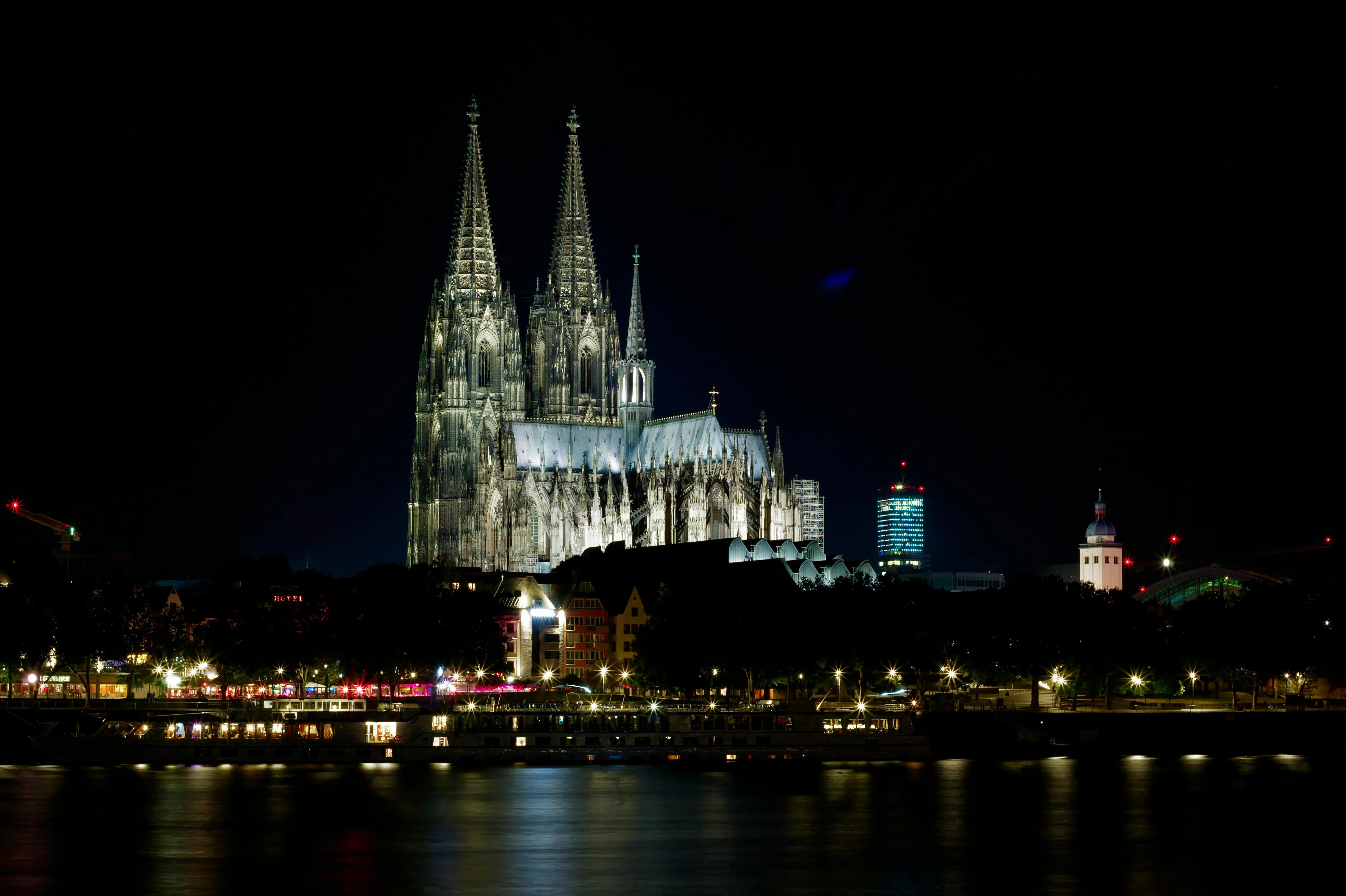 Gothic Cologne Cathedral spires at sunrise with Rhine River mist, stone facade, and morning light in Germany