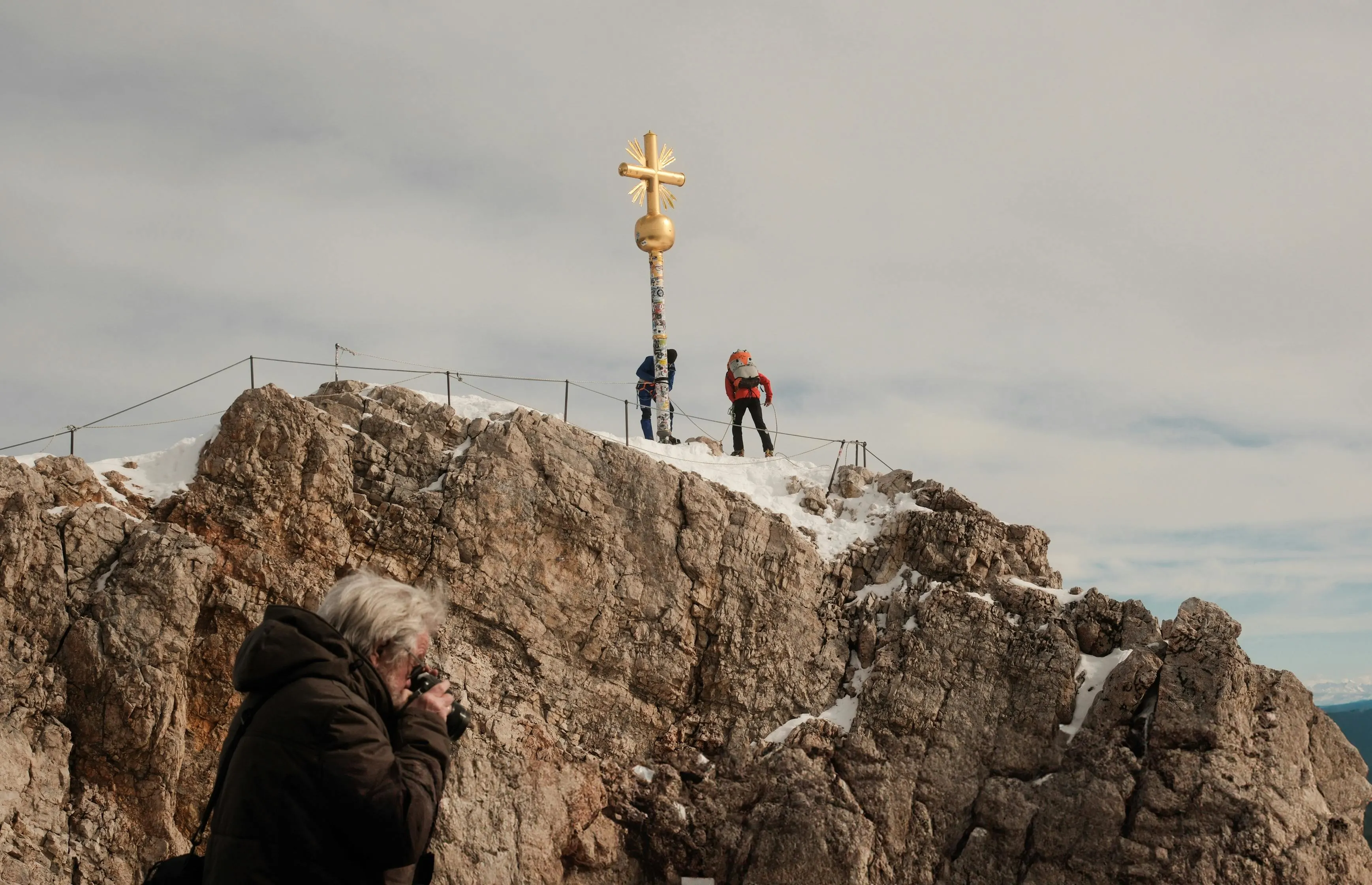 Zugspitze summit at sunrise with golden cross, snow-covered peaks, and Bavarian Alps background in Germany