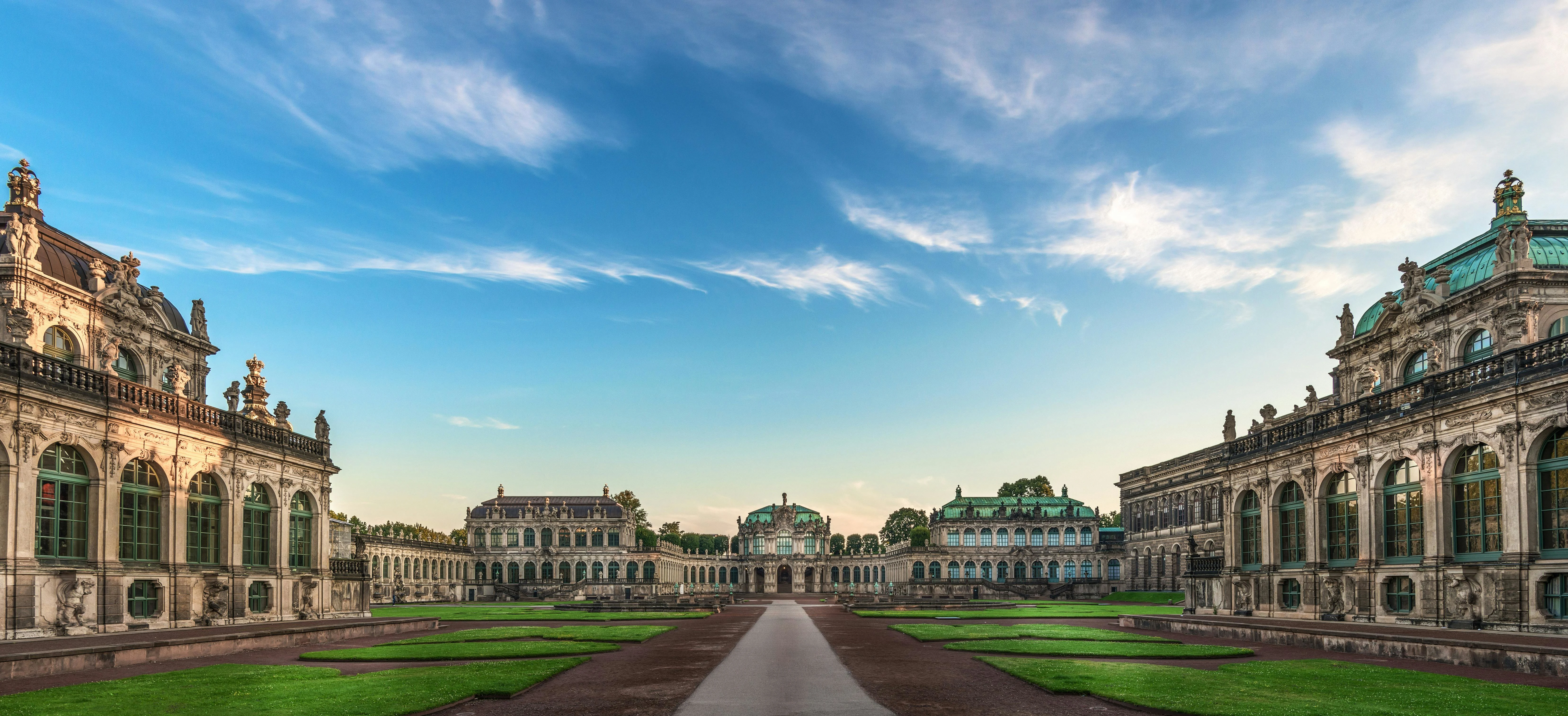 Zwinger Palace baroque courtyard at sunrise with ornate pavilions, fountains, and Dresden skyline in Saxony Germany