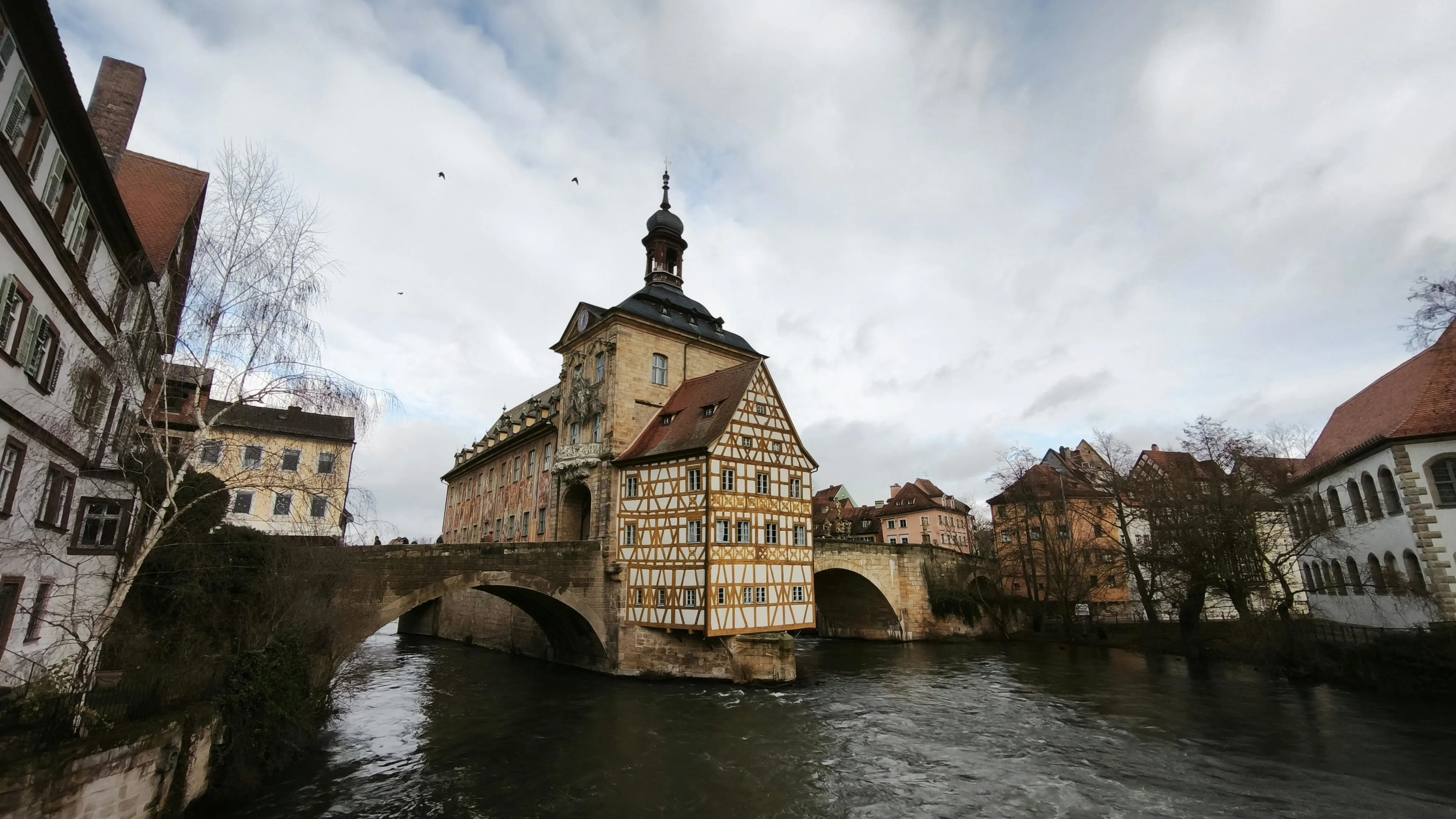 Bamberg Old Town cathedral spires at sunrise with Regnitz River, half-timbered houses, and misty Franconian morning in Germany