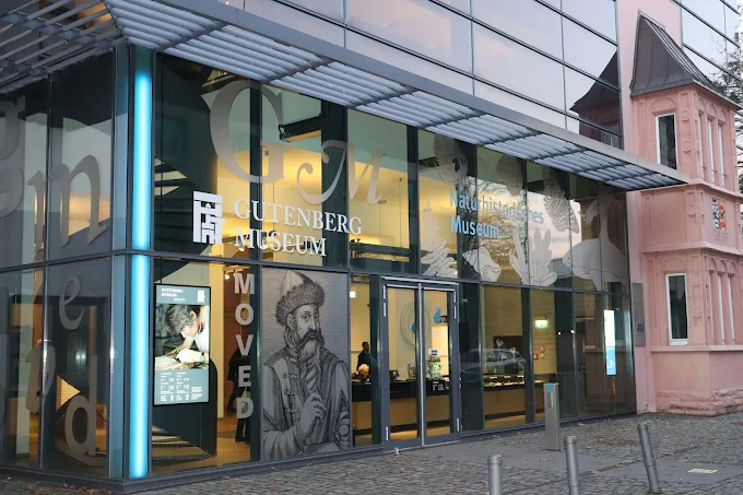 Mainz Gutenberg Museum interior at dawn with antique printing press, ink stains, and historic manuscripts in Germany