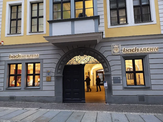 Leipzig Bach Museum interior at dusk with antique harpsichord, handwritten manuscripts, and warm lighting in Saxony Germany