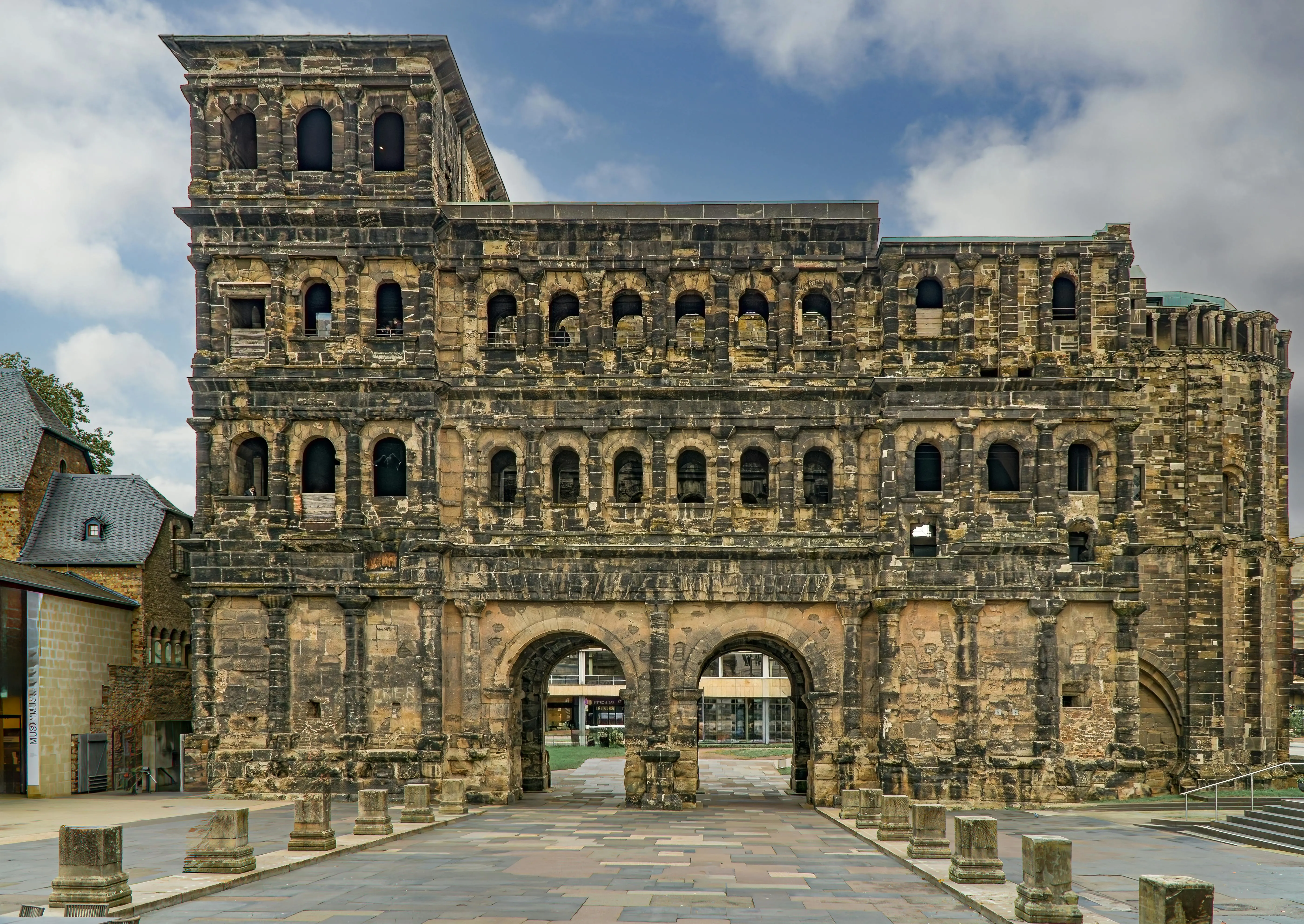 Trier Porta Nigra Roman gate at sunrise with ancient sandstone blocks, mossy walls, and morning mist in Germany