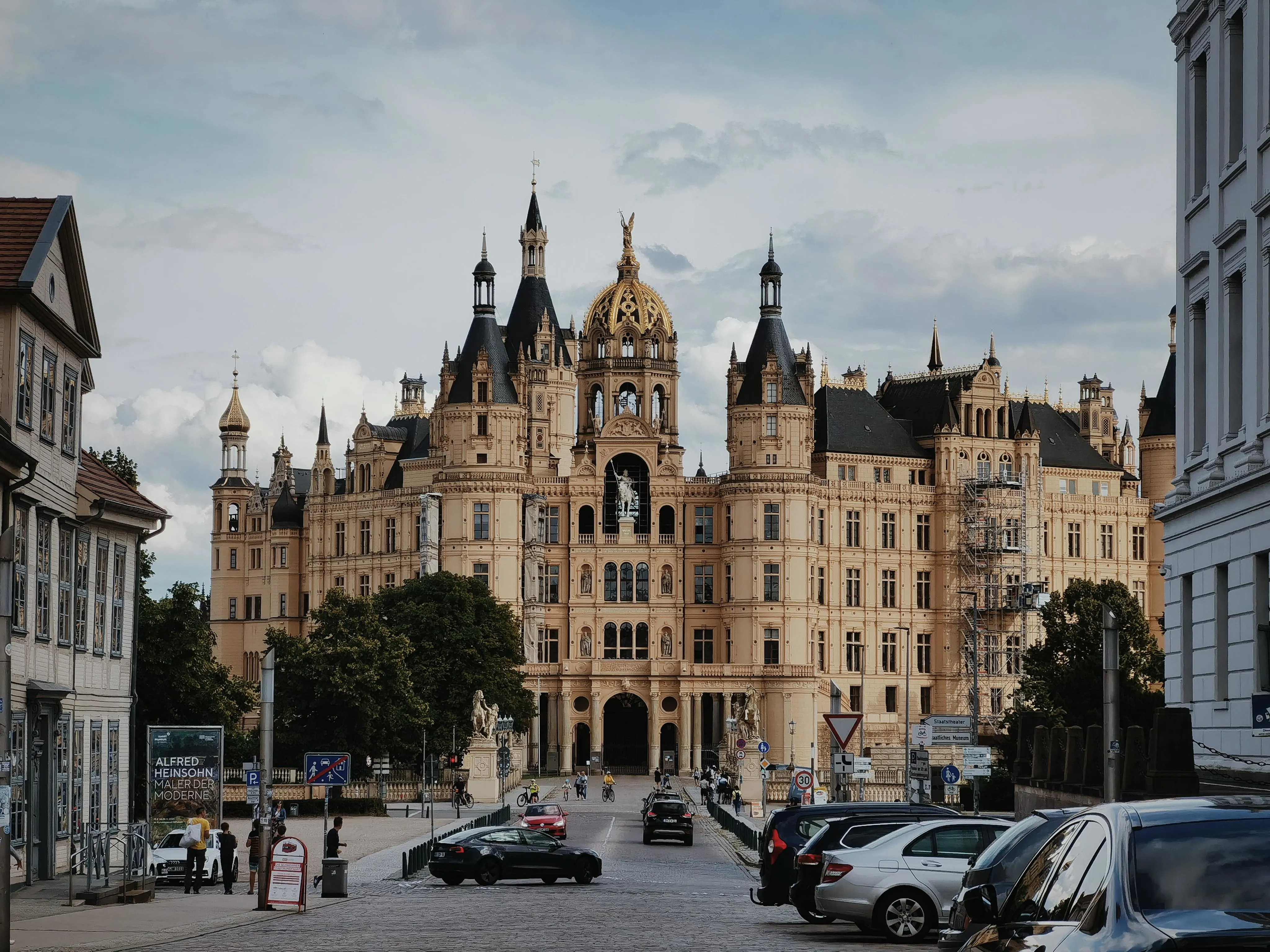 Schwerin Castle on island at sunrise with golden domes, lake reflection, and lush gardens in Mecklenburg Germany