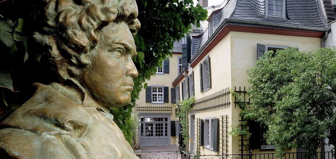 Bonn Beethoven House facade at sunrise with yellow stucco, cobblestone street, and morning light in Germany