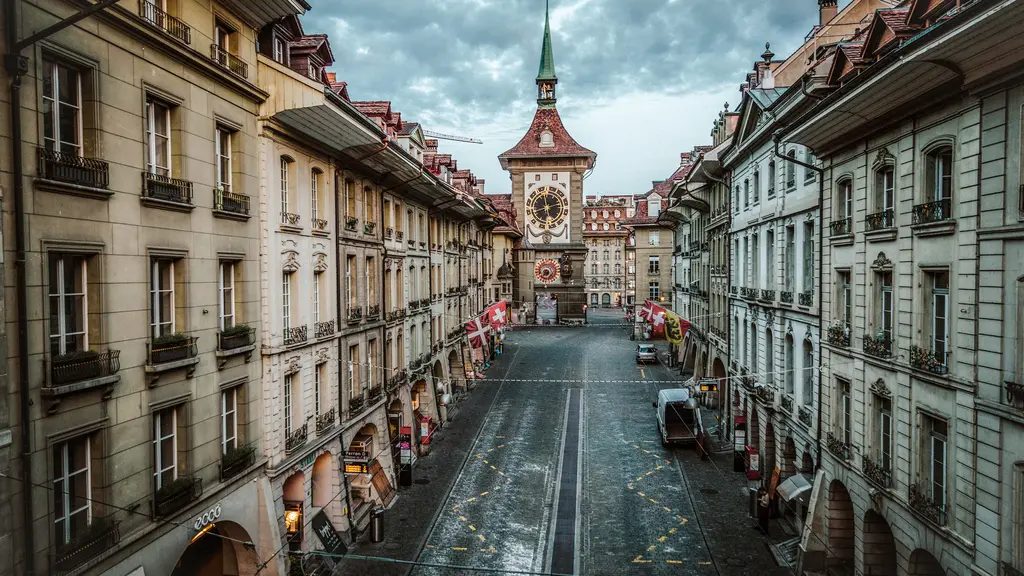 Bern old town Zytglogge tower at sunrise with medieval arcades, Aare River, and morning mist in Switzerland