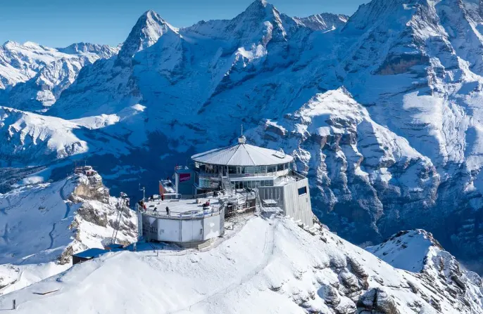 Schilthorn Piz Gloria summit at sunrise with revolving restaurant, snow-covered Alps, and Bernese Oberland view in Switzerland