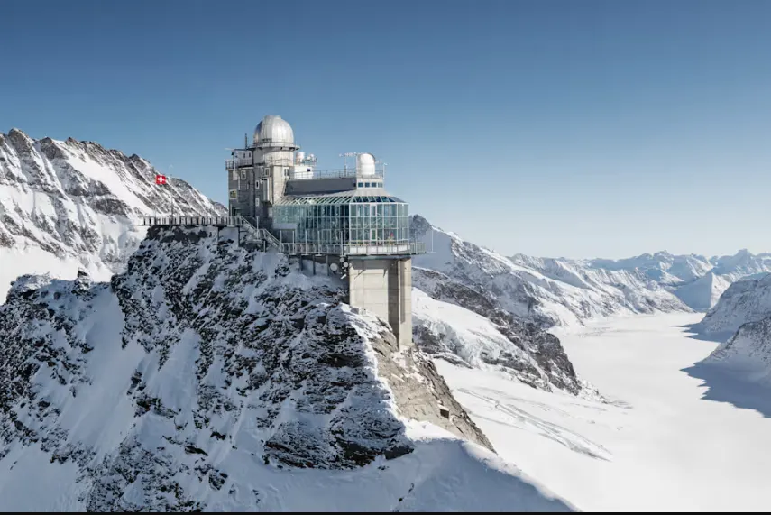 Jungfraujoch Top of Europe at sunrise with snow-covered peaks, Sphinx Observatory, and alpine glacier in Switzerland