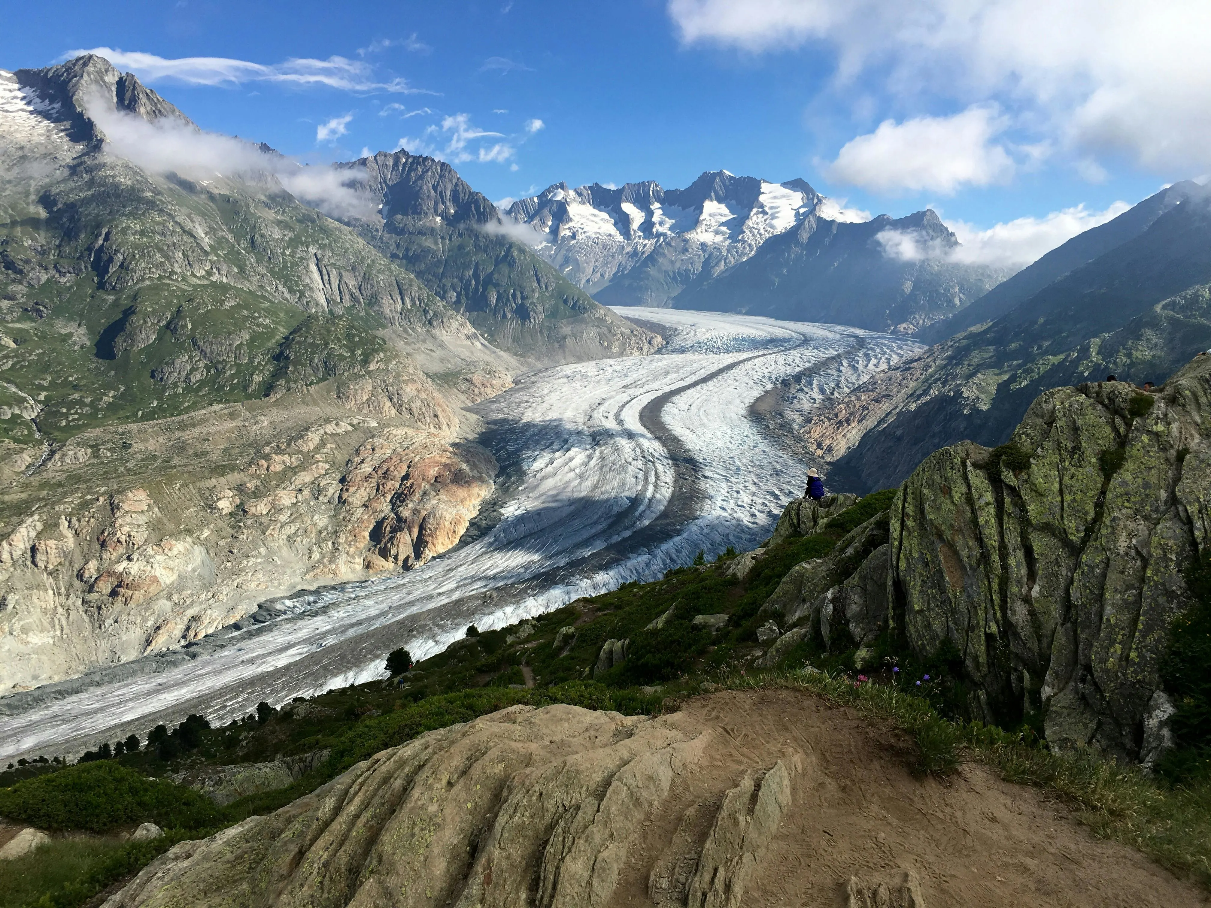 Aletsch Glacier ice field at sunrise with snow-covered peaks, alpine forest, and morning mist in Switzerland