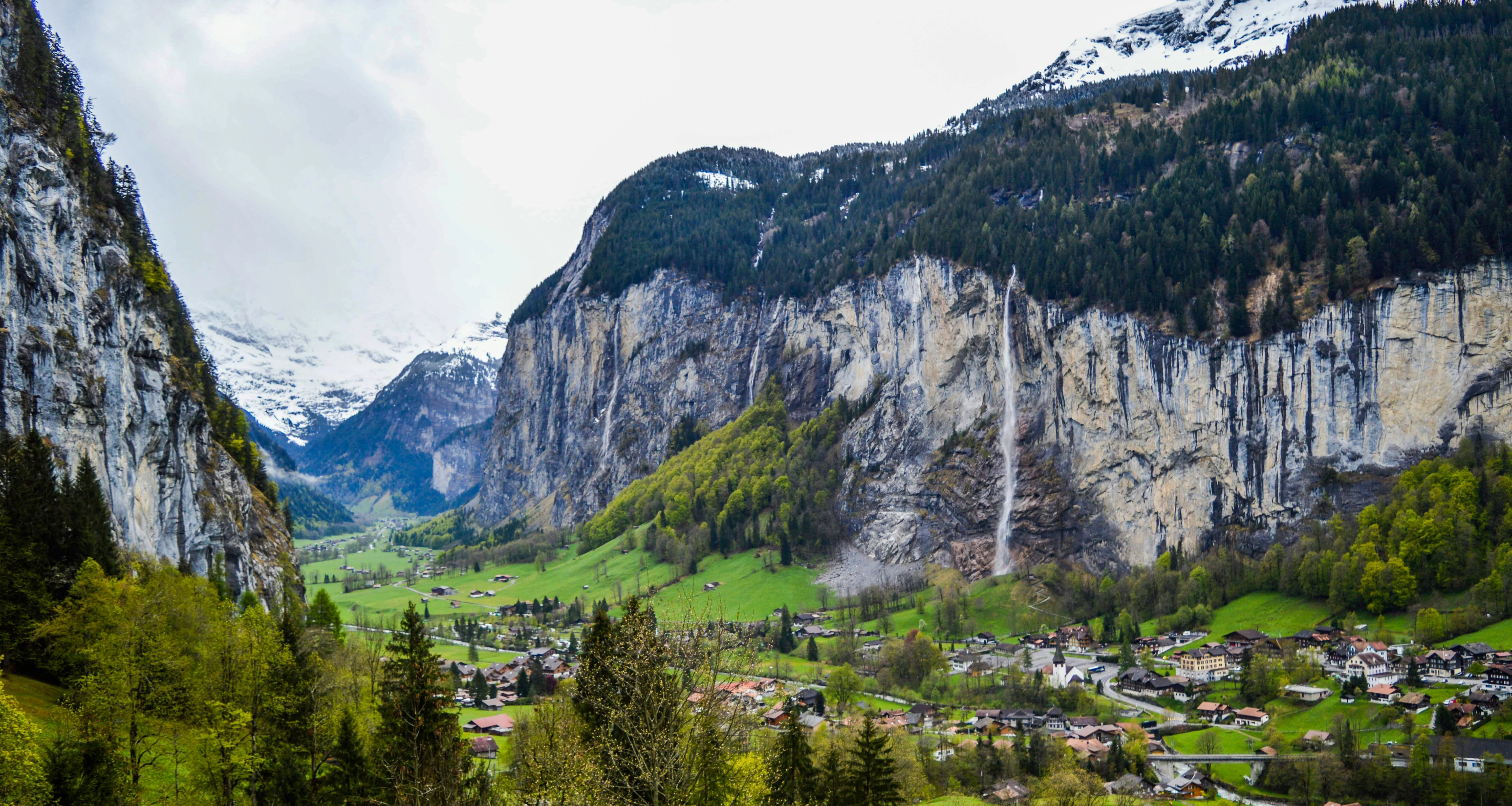 Grindelwald village at sunrise with wooden chalets, Eiger North Face, and green valley in Switzerland