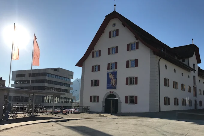Schwyz town square at sunrise with historic buildings, Mythen peaks backdrop, Canton Schwyz morning light and Swiss flag