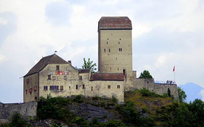 Sargans Castle medieval fortress at sunset with stone towers, Rhine valley backdrop, St. Gallen canton evening light and Alpine peaks