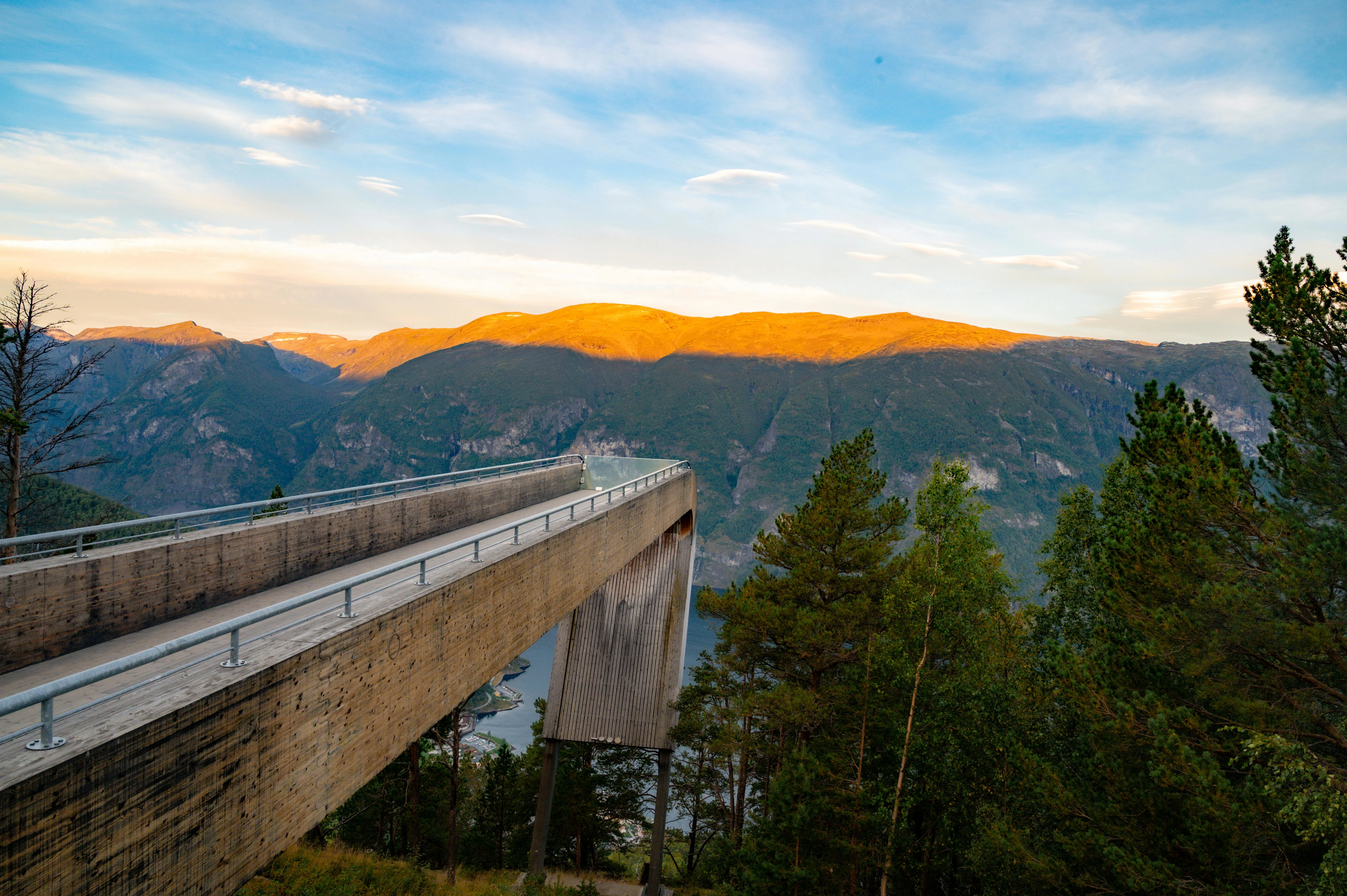 Stegastein viewpoint cantilevered platform extending over Aurlandsfjord, Norway, dramatic mountain landscape, morning sunlight and mist