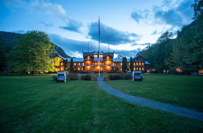 Dalen Telemark Norway at sunset with historic Dalen Hotel dragon towers and calm Bandak lake waters reflecting golden light