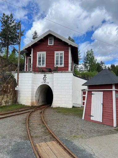 Kongsberg Silver Mines underground tunnel with dim lantern light illuminating historic wooden structures and rocky walls