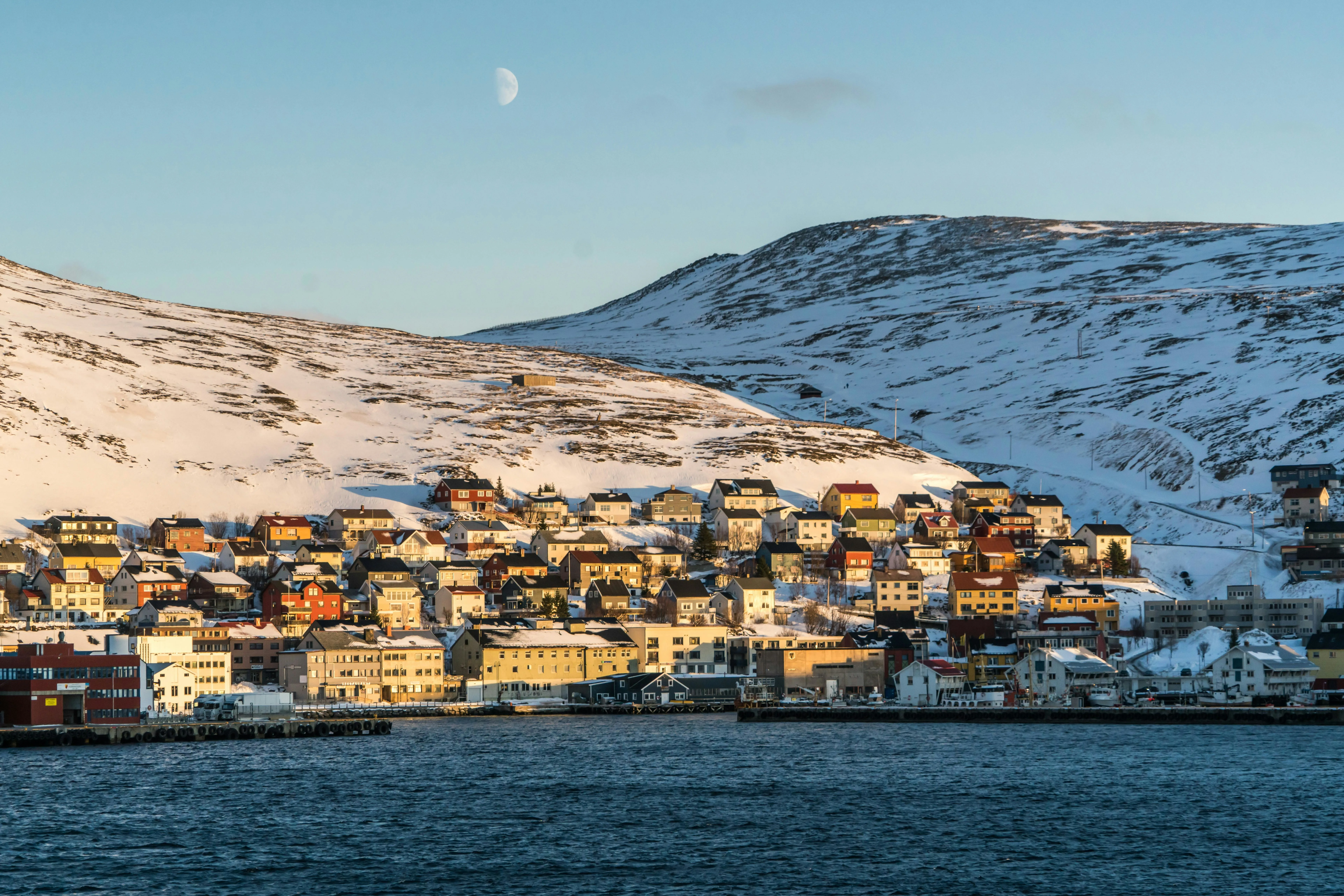 Colorful historic timber houses of Ísafjörður fjord town in Westfjords Iceland surrounded by steep mountains at sunset