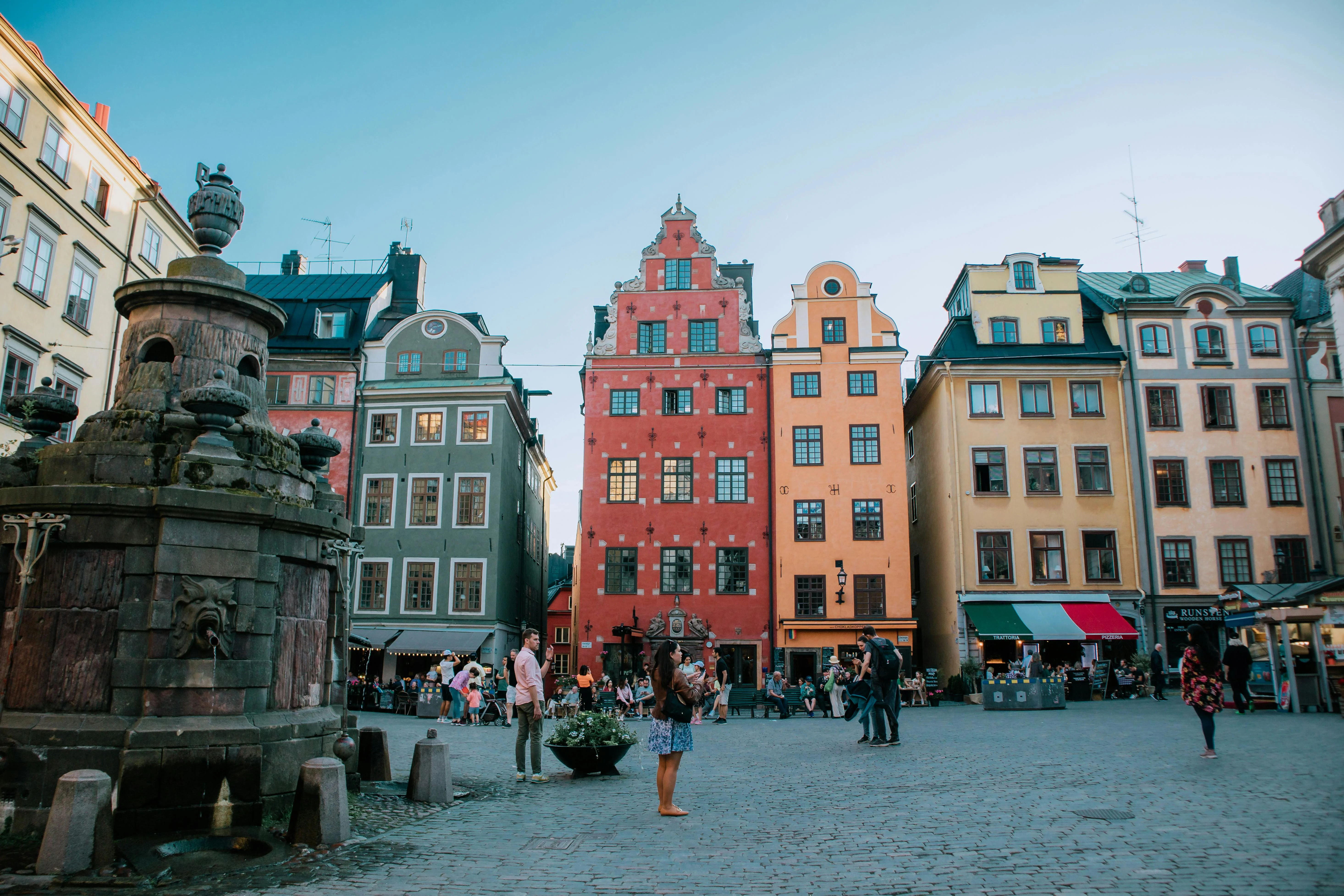 Cobblestone streets of Gamla Stan illuminated by warm streetlights at twilight with colorful medieval buildings lining the alley